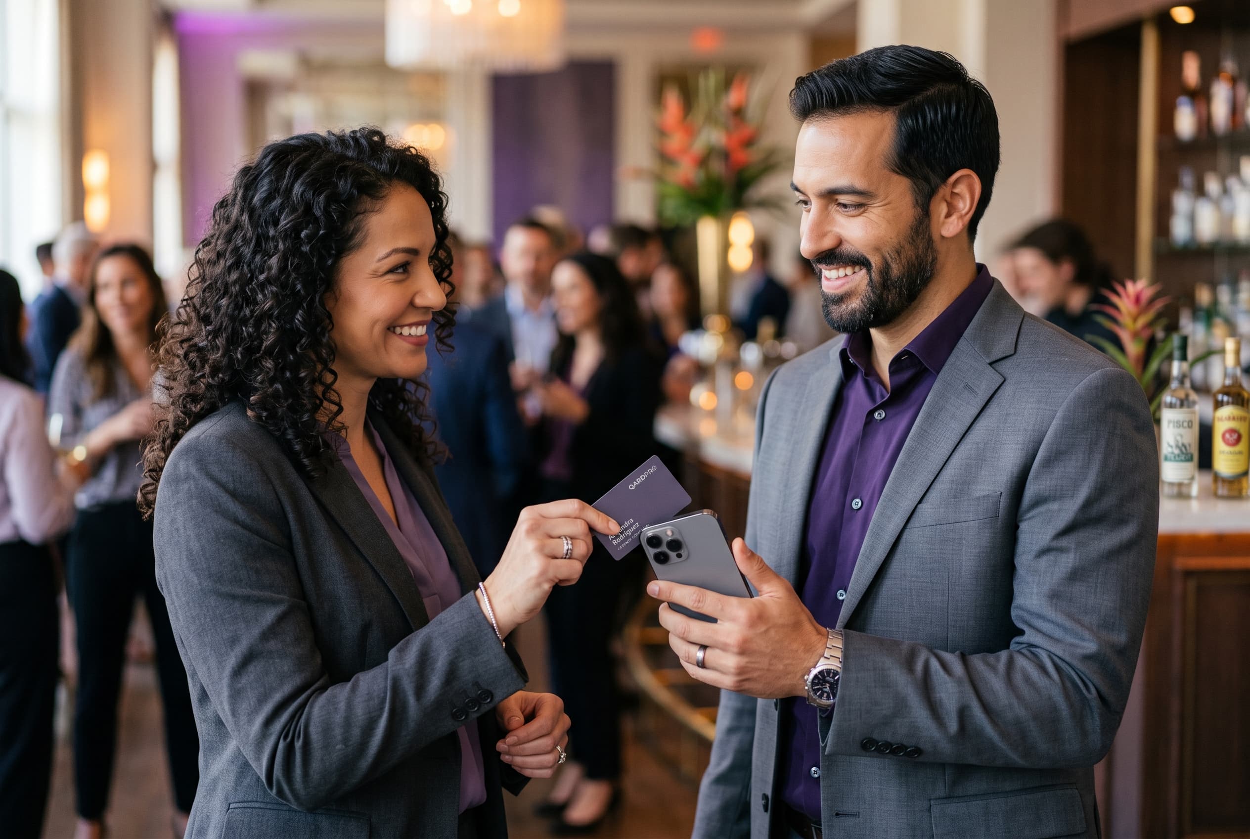 Una profesional acerca su tarjeta QARDPRO al celular de otra persona durante un evento de networking